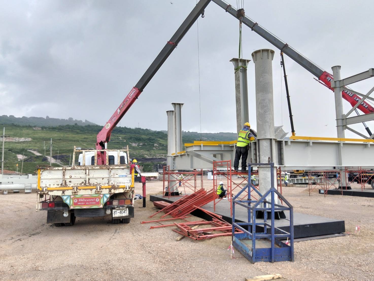 Engineering team supervising steel column installation at a plant construction site